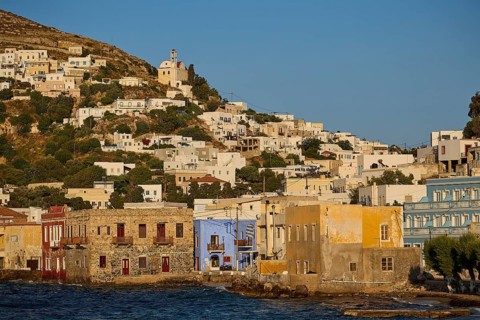 Coastal town with colourful houses along the water, church on the hill above the town, Agia Marina,