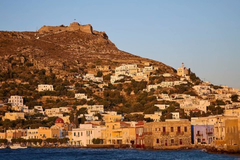 Panteli Fortress, Greek coastal village against a backdrop of hills at sunset, with traditional