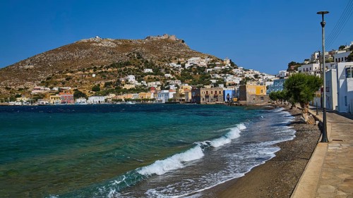 Panteli Fortress, seafront promenade of a coastal town with waves and beautiful hills, Agia Marina,