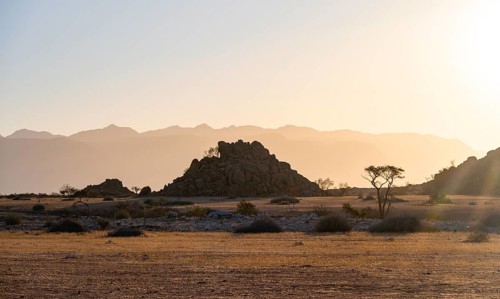 Desert landscape in the evening light at sunset, barren landscape with hills of stacked rocks,