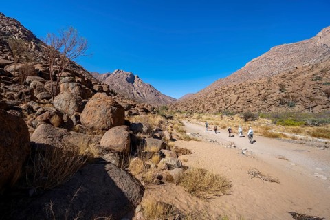 Tourists on a hiking trail in the Tsisab Gorge, White Lady Trail, desert landscape, Brandberg,