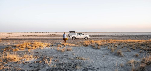 Tourist with off-road car exploring dry landscape, Kubu Island (Lekubu), Sowa Pan, Makgadikgadi