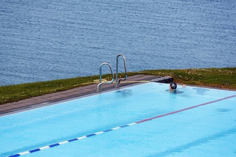 View from above of swimming pool by the sea, thermal bath, heated outdoor pool in Hofsos at the