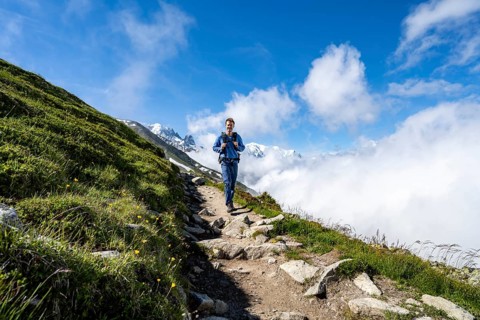 Mountaineer on a hiking trail, inversion weather situation with clouds in the valley, Chamonix,