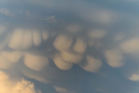Unusual cloud structures create captivating shapes against a backdrop of warm colours as the sun