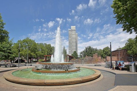 Round torch fountain by Friedrich Korter 1939 and town hall, water fountain with water basin, water