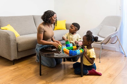 Mother, son and daughter enjoying quality time together, playing with colorful building blocks in