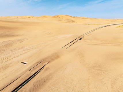 Rails covered with sand in the southern Namib Desert. Aerial view. Drone shot. Namibia