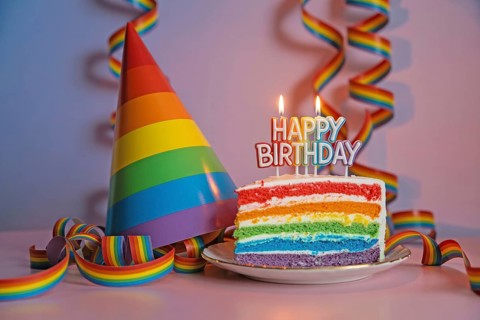 Rainbow party cake slice with matching rainbow hat and festive streamers. Generative ai, AI