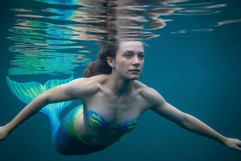 Mermaid swimming underwater with tropical fish in blue ocean. Generative ai, AI generated