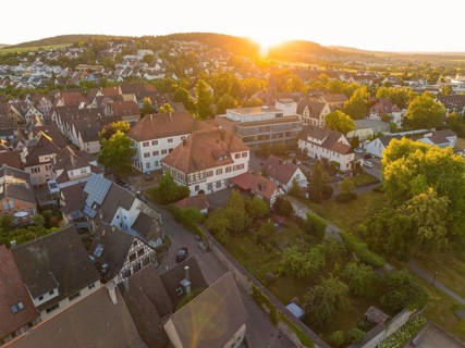 Peaceful sunset over a village with houses and lush vegetation in the landscape, 950 years Weil der