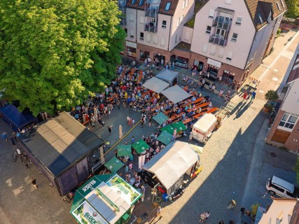 Large crowd at an open-air event, surrounded by buildings and trees, 950 years Weil der Stadt