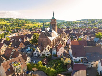 Aerial view of a village with a central church and surrounding half-timbered houses, 950th