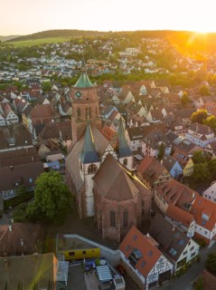 Aerial view of a church and old town centre in the evening light with surrounding landscape, 950