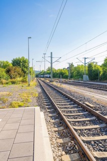 View along the railway tracks in a green environment, clear sky, feeling of travelling, Weil der