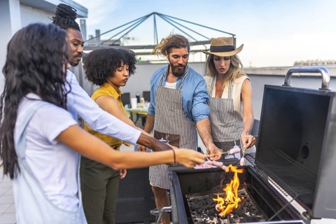 Chefs grilling sausages on a rooftop, enjoying a lively party with friends, creating delicious