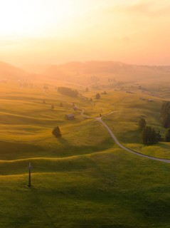 Hilly landscape at sunset with winding paths and warm light, Alpe di Siusi, Dolomites, South Tyrol,