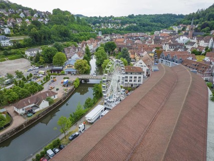 Aerial view of a town with a Ferris wheel in the centre, surrounded by densely built-up houses and