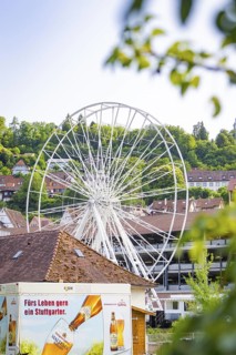 White Ferris wheel with buildings and advertising in the foreground, Ferris wheel construction for