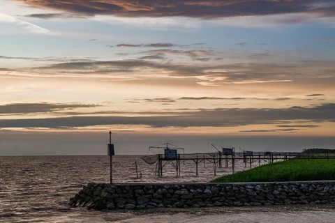 Sunset over Fishing huts over Gironde Estuary, Braud-et-Saint-Louis, France
