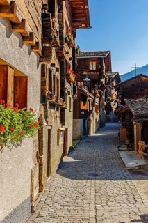 Old wooden houses decorated with flowers, in the village street, historic village centre, Grimentz,