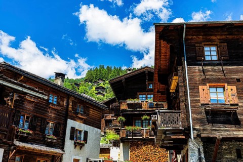 Old wooden houses in log construction, decorated with flowers, historic village centre, Grimentz,
