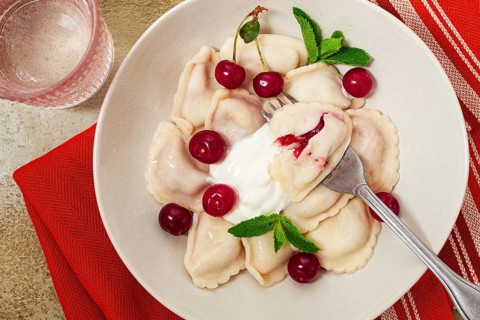 Traditional dumplings with cherries and yogurt, close-up, no people