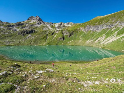 Hiker at lake Engeratsgundsee, mountain range between Oberstdorf and Bad Hindelang, Allgaeu,