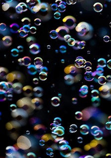 Many, small iridescent and floating soap bubbles against a black background, Recklinghausen, North