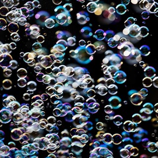 Many, small iridescent and floating soap bubbles against a black background, Recklinghausen, North