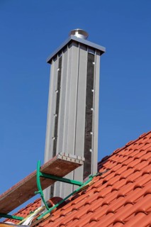 Chimney with high-quality titanium zinc cladding on a straight tiled roof