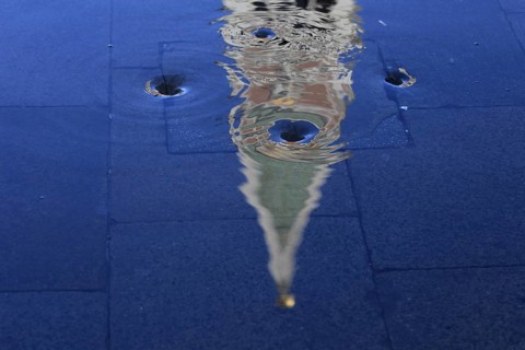 Reflection of the Campanile with water vortex of the flowing flood water, Acqua alta, Venice,