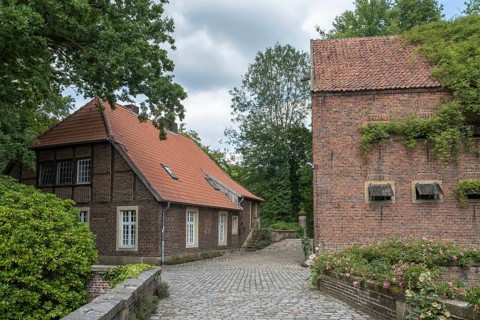 Idyllic rural scene with a half-timbered house and brick building under a cloudy sky, Haus