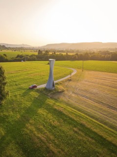 Observation tower with a winding path and hilly landscape at sunset