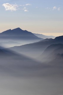 Mountain silhouettes... Alpine peaks and mountain ranges in the Bavarian Alps, light fog rises from