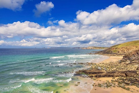 Rocky coastline with breaking waves on the shore and a scenics view to the horizon a sunny summer
