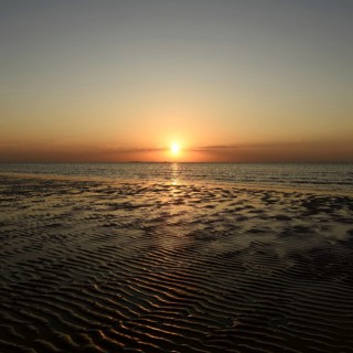 Sunset over the Wadden Sea on the German North Sea coast, low sun over Neuwerk, typical ripple