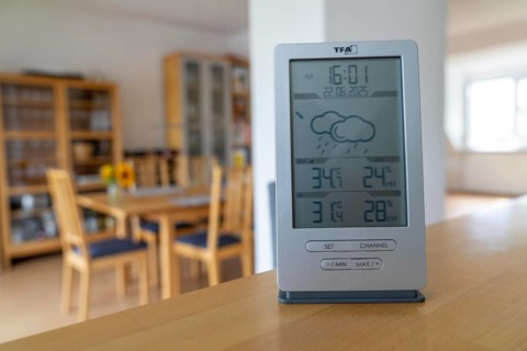 Summer heat, digital thermometer in an attic flat, city centre, outside temperature in the