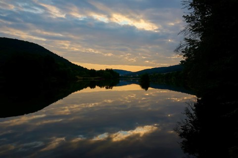 A calm river at dusk with dramatic clouds reflected in the water, summer, Grünenwört, Wertheim,