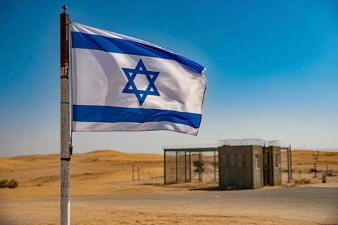 Israeli flag waving in desert wind near military checkpoint under harsh sunlight. Generative ai, AI