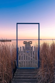 View along a footbridge through a door frame to the Steinhuder Meer in the evening light, Great