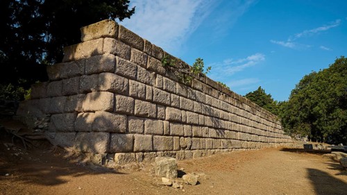 Stone wall in a natural setting with clear blue sky, Wall Upper Terrace, Asklipion, Asklepieion,