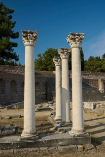 Three ancient columns in a historic landscape of ruins with clear sky, Temple of Apollo, Corinthian