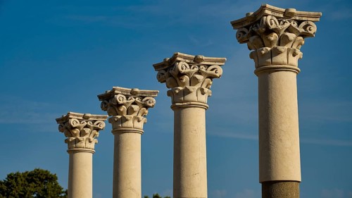 Four ancient columns with ornate capitals against a backdrop of a clear sky, Temple of Apollo,