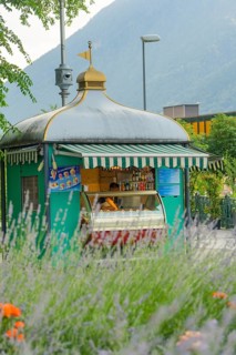 A pretty ice cream shop with a traditional roof, surrounded by lavender and summery nature, Merano,