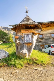 Whimsical wooden petrol station in a rural setting with car and meadow, Alpe di Siusi, Dolomites,