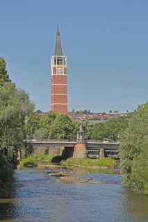 Town church built in 1968 and Auerbrücke bridge with rafters' monument over the River Enz,