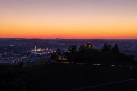Evening atmosphere with chapel and city lights, silhouette of the vineyards at sunset, grave
