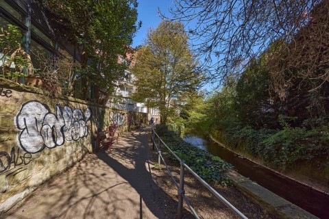 Footpath, sandstone wall, graffiti, metal railing, river Münstersche Aa, trees, bushes, shadow,