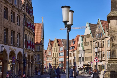 Old town, historical buildings, lantern, pedestrians as secondary motif, blue cloudless sky,